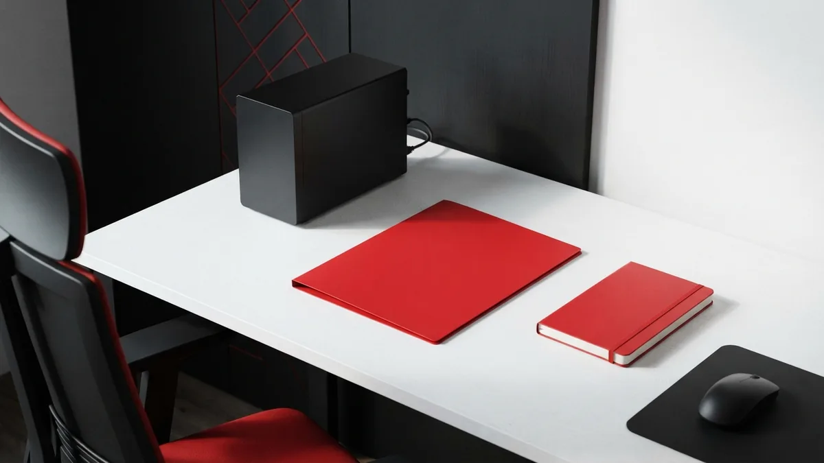 Clean home office setup with a crimson folder, white desk, and black server box