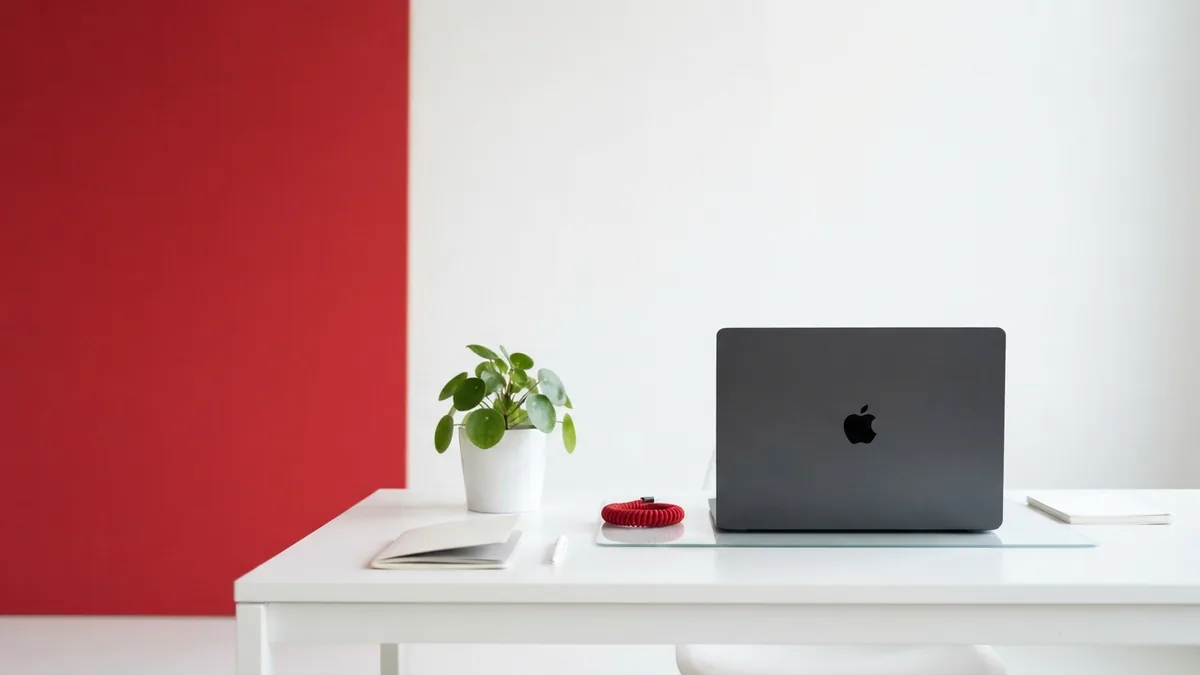 A simple setup for hosted WordPress sites Modern desk with laptop, plant, glass, and red cable detail for a hosted website setup