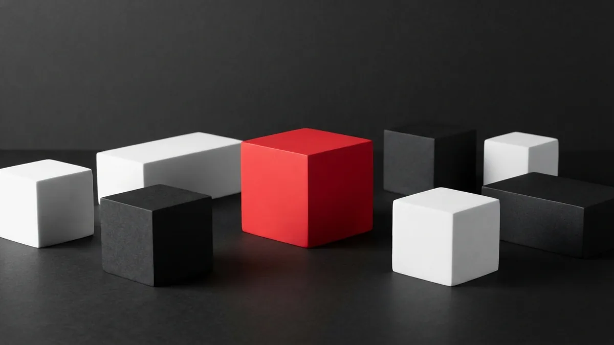 Geometric white and graphite blocks with a crimson red cube