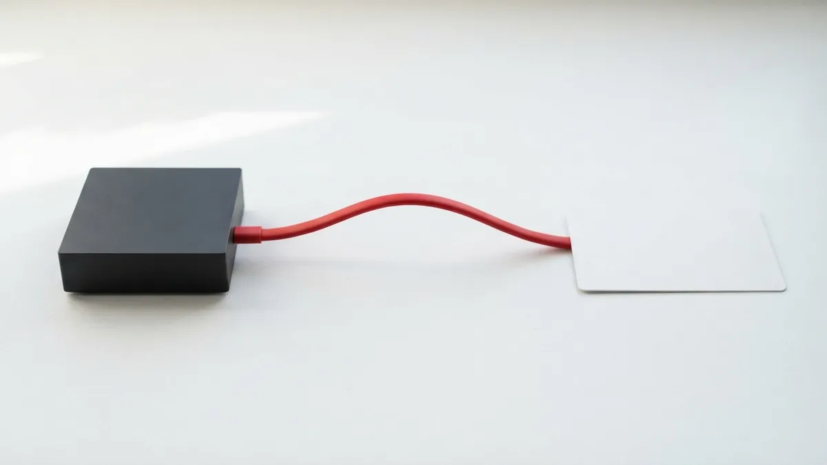 Crimson cable linking a graphite box and a plain white card