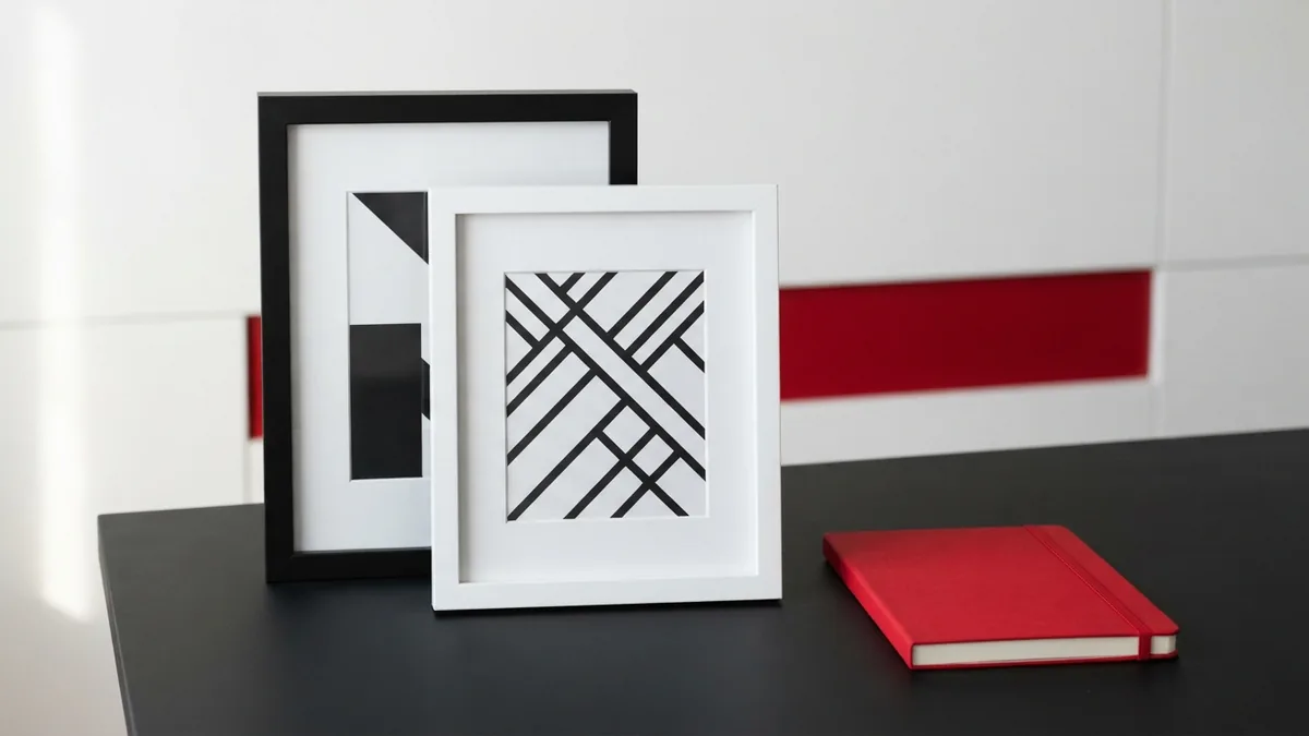 White and graphite image frames beside a crimson red notebook for slider editing