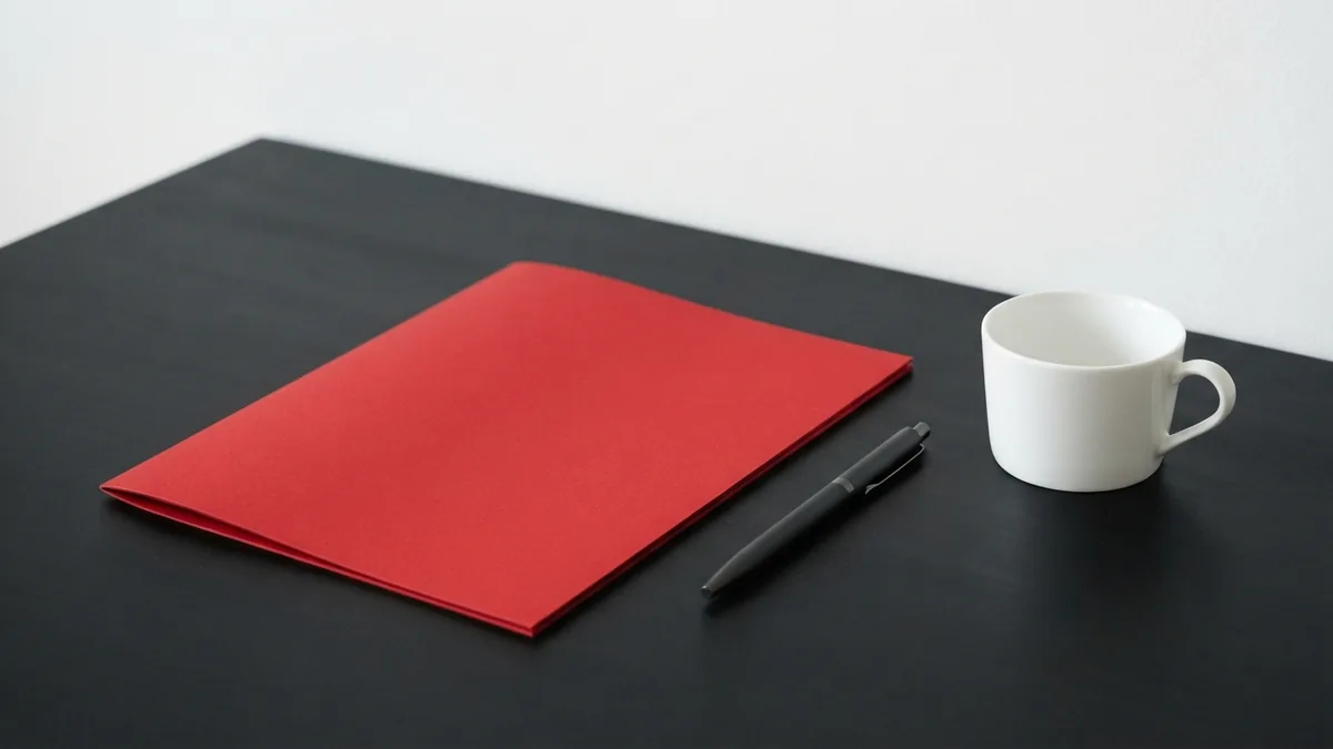 Planning client meetings and outreach Crimson folder and simple desk items set out for client meetings and business outreach