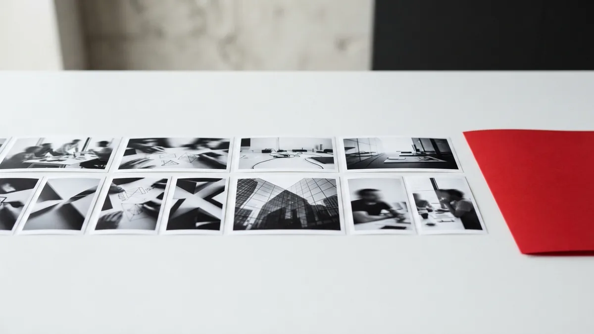Simple photo gallery layout Monochrome prints arranged beside a crimson folder for a simple photo gallery concept